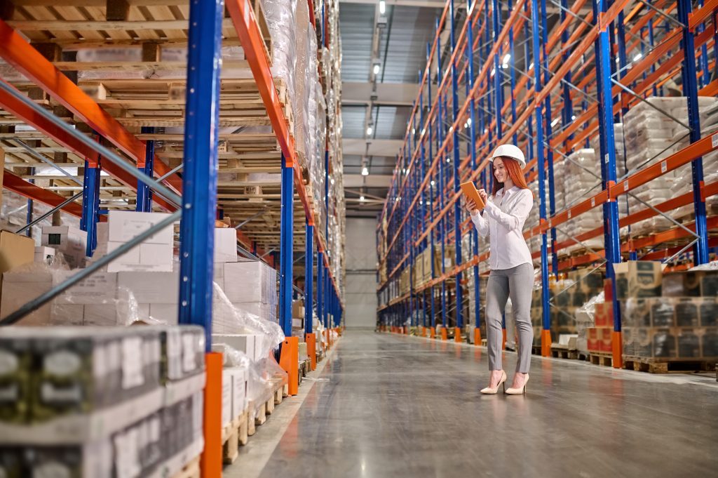 woman working on tablet standing in warehouse
